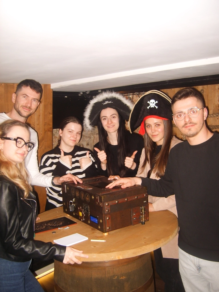 impreza firmowa w klimacie pirackim - grupa ludzi świetnie bawi się w escape room Wawel